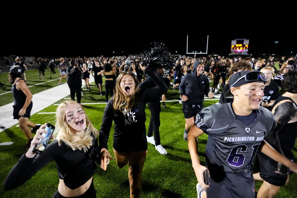 Pickerington North students storm the field a 39-34 win over Pickerington Central on Friday.