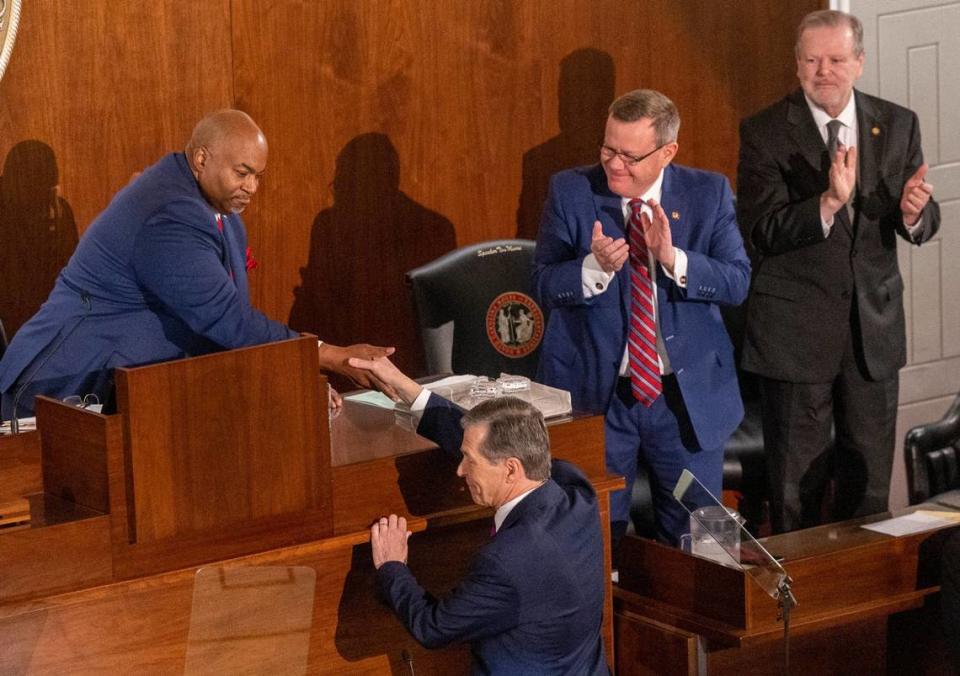 Gov. Roy Cooper shakes hands with Lt. Gov. Mark Robinson as House Speaker Tim Moore and Senate Leader Phil Berger look on after Cooper delivered his State of the State address to a joint session of the N.C. General Assembly on Monday, March 6, 2023.
