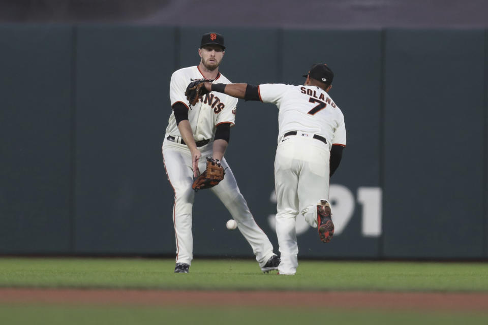 San Francisco Giants' Austin Slater, left, and Donovan Solano, right, cannot reach a single hit by Arizona Diamondbacks' Christian Walker during the first inning of a baseball game in San Francisco, Thursday, Sept. 30, 2021. (AP Photo/Jed Jacobsohn)