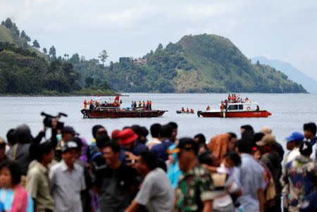 Rescue team members during an operation, as relatives of the missing passengers after a ferry sank earlier this week in Lake Toba, are waiting at Tigaras port in Simalungun, North Sumatra, Indonesia, June 22, 2018. REUTERS/Beawiharta