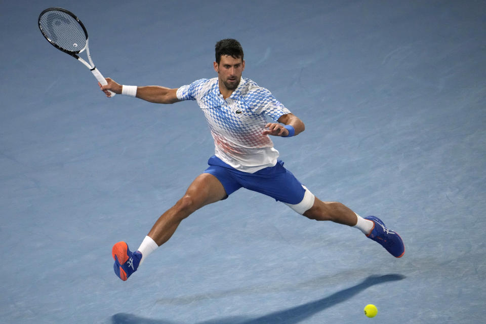 Novak Djokovic of Serbia plays a forehand return to Andrey Rublev of Russia during their quarterfinal match at the Australian Open tennis championship in Melbourne, Australia, Wednesday, Jan. 25, 2023. (AP Photo/Ng Han Guan)
