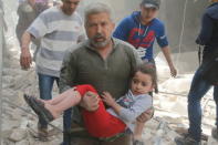 A man carries an injured girl after an airstrike in the rebel held area of old Aleppo. REUTERS/Abdalrhman Ismail