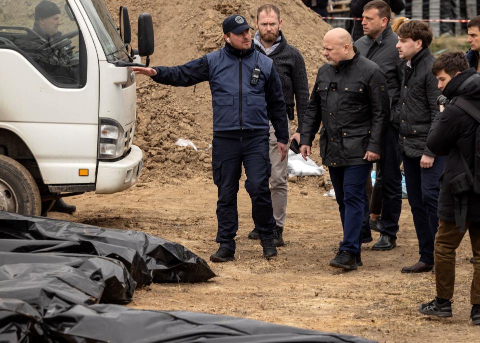 Prosecutor of the International Criminal Court, Britain's Karim Khan (4th R), visits a mass grave in Bucha, on the outskirts of Kyiv, Ukraine, April 13, 2022, amid Russia's military invasion of Ukraine. / Credit: FADEL SENNA/AFP/Getty