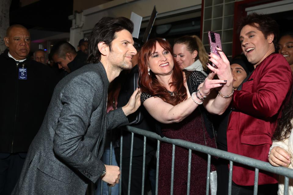 Adam Scott takes a selfie with a fan at the Hollywood premiere of "Madame Web." He plays Ben Parker, better known in comic-book lore as Spider-Man's uncle.