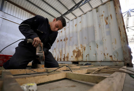 A worker transforms an old steel shipping container which may later be used as living spaces or shops or restaurants in Cairo, Egypt April 19, 2017. Picture taken April 19, 2017. REUTERS/Mohamed Abd El Ghany