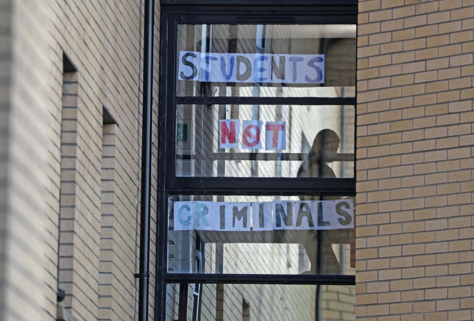 A student walks past a sign at Murano Street Student Village in Glasgow, where Glasgow University students are being tested at a pop up test centre. (PA)