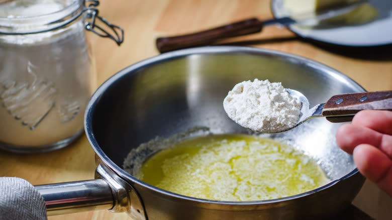 adding spoon of flour to pot