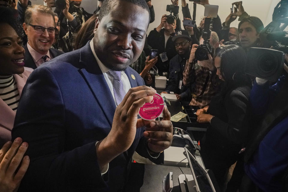 Chris Alexander, center, executive director of New York State Office of Cannabis Management, shows off the first purchase of cannabis gummies bought at Housing Works, New York's first legal cannabis dispensary, during a press conference to kick-off its opening, Thursday Dec. 29, 2022, in New York. Housing Works, a minority-controlled nonprofit serving people with HIV and AIDS, as well as homeless and formerly incarcerated people, will be the first of 36 recently licensed dispensaries to begin selling cannabis to the general public. (AP Photo/Bebeto Matthews)