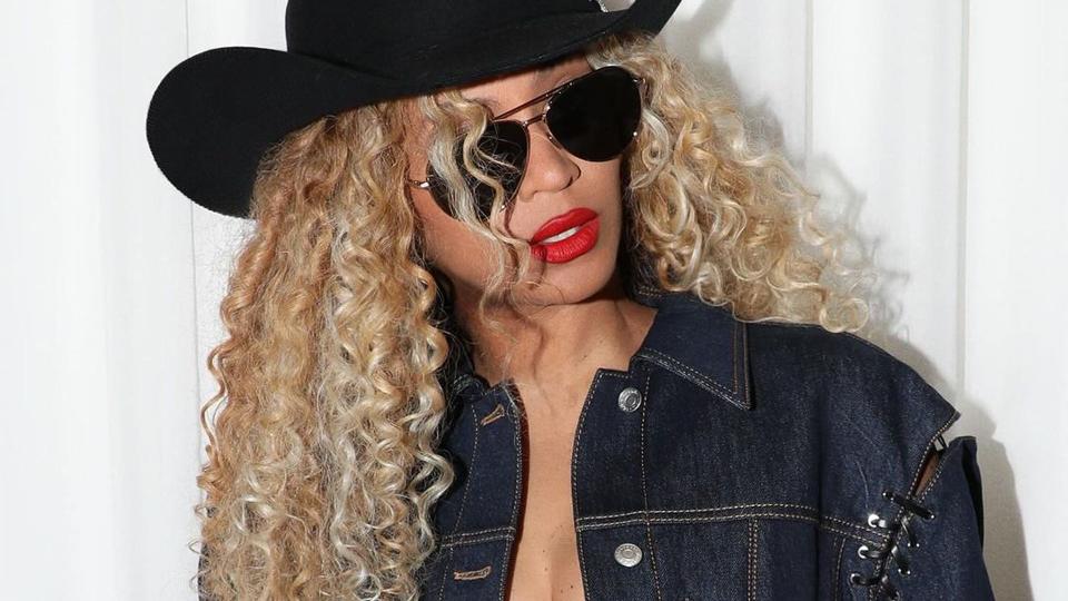 Beyoncé with curly hair and a black cowboy hat