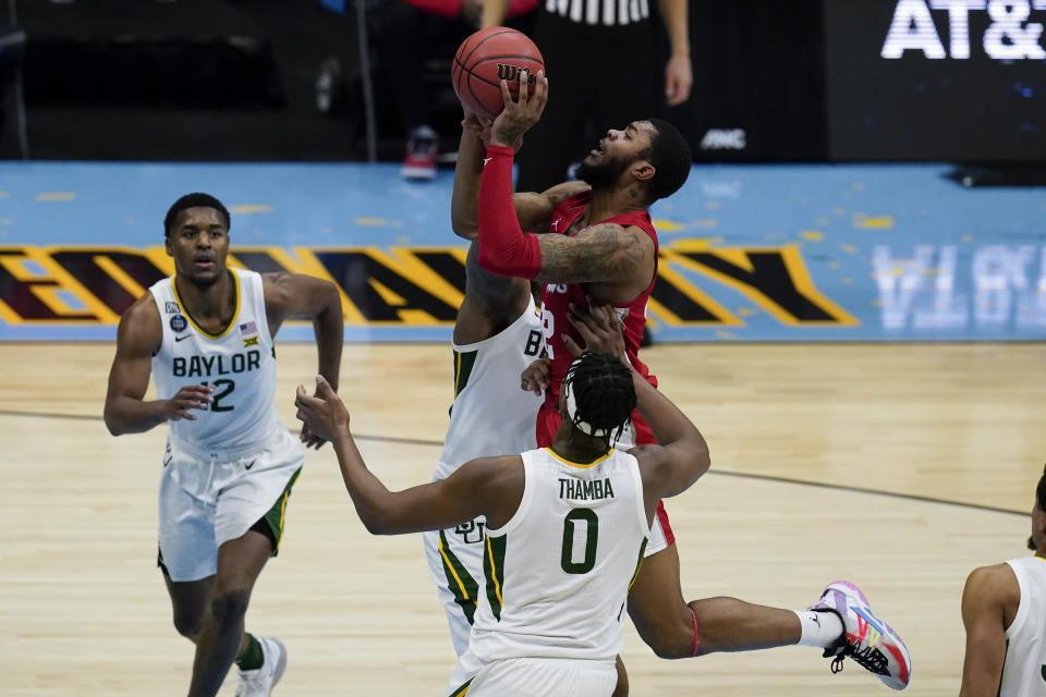 Houston forward Reggie Chaney, top, shoots over Baylor forward Flo Thamba (0) during the second half of a men's Final Four NCAA college basketball tournament semifinal game, Saturday, April 3, 2021, at Lucas Oil Stadium in Indianapolis. (AP Photo/Michael Conroy)