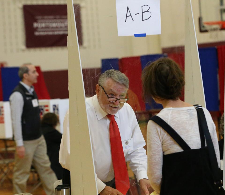 A ballot clerk at the Portsmouth polling station checks voters in at Ward 2 Nov. 8, 2022.