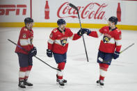 Florida Panthers center Sam Reinhart (13) is congratulated by centers Eetu Luostarinen (27) and Aleksander Barkov (16) after Reinhart scored during the third period of an NHL hockey game against the Toronto Maple Leafs, Tuesday, April 16, 2024, in Sunrise, Fla. (AP Photo/Wilfredo Lee)