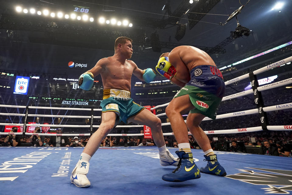 Canelo Alvarez, left, exchanges punches with Billy Joe Saunders during a unified super middleweight world championship boxing match, Saturday, May 8, 2021, in Arlington, Texas.(AP Photo/Jeffrey McWhorter)