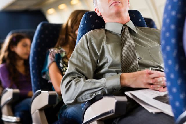 <p>Getty</p> Stock image of a passenger reclining his seat on a plane