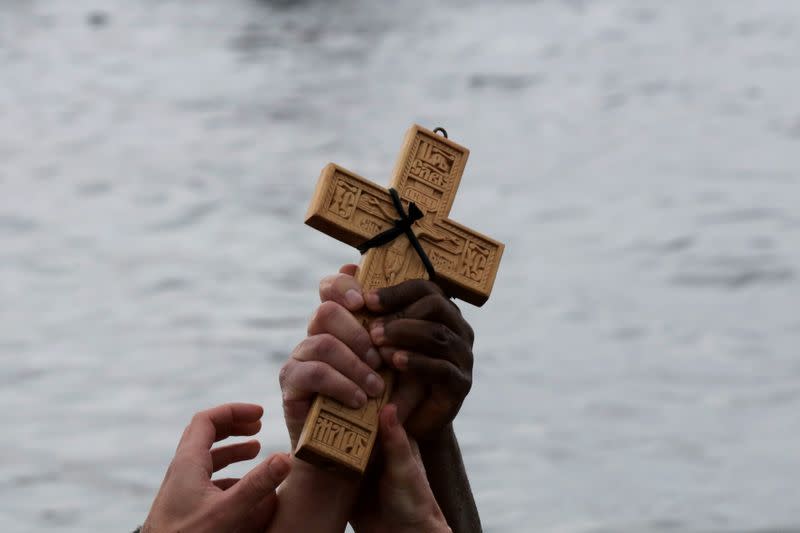 FILE PHOTO: Orthodox faithful raise a wooden crucifix during Epiphany day celebrations in the southern suburb of Faliro in Athens