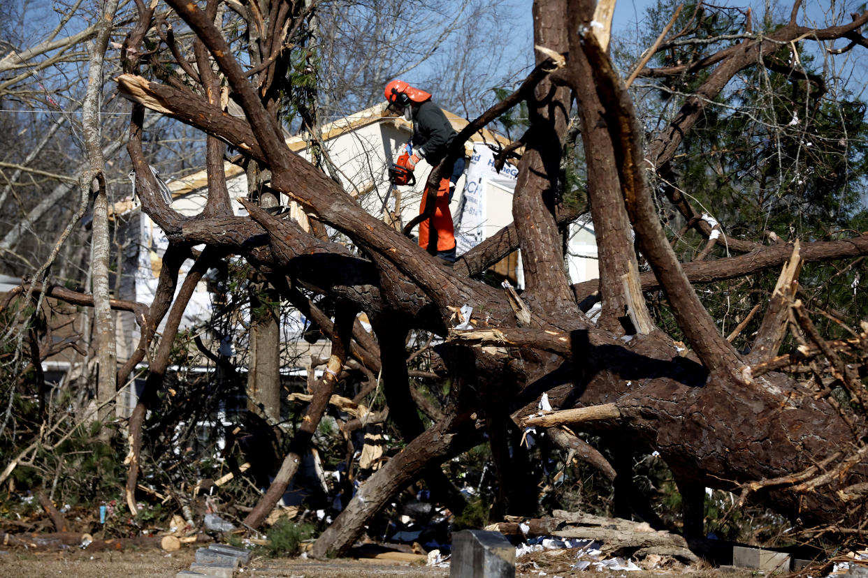 Workers remove fallen trees as they begin to recover from a tornado that ripped through Central Alabama earlier this week Saturday, Jan. 14, 2023 in Marbury, Ala. Stunned residents tried to salvage belongings as rescue crews pulled survivors from the aftermath of a deadly tornado-spawning storm system. (AP Photo/Butch Dill)