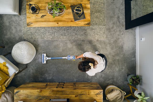 <p>Getty</p> Stock image overhead view of woman vacuuming
