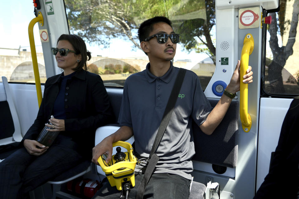 An attendant keeps an eye on the road from inside a driverless shuttle as it transports passengers on San Francisco's Treasure Island on Aug. 16, 2023. He can manually drive the autonomous bus with a handheld controller if necessary. The free bus service was launched less than a week after California regulators approved the controversial expansion of robotaxis on city streets. (AP Photo/Terry Chea)