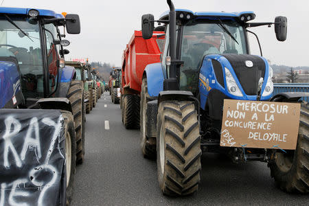 French farmers drive their tractors on the A7 highway to protest changes in underprivileged farm area’s mapping and against Mercosur talks, in Pierre-Benite near Lyon, France, February 21, 2018. Message reads "Mercosur, no to unfair competition". REUTERS/Emmanuel Foudrot