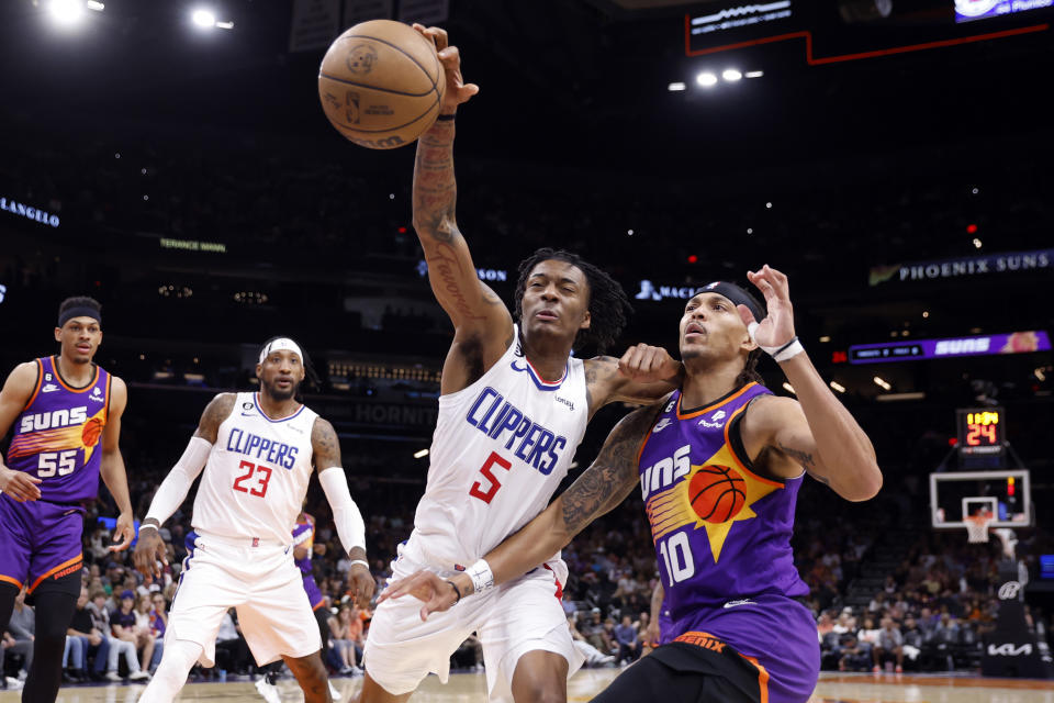 Bones Hyland of the Los Angeles Clippers attempts to grab a loose ball over Damion Lee of the Phoenix Suns on Sunday at the Footprint Center in Phoenix. (Chris Coduto/Getty Images)