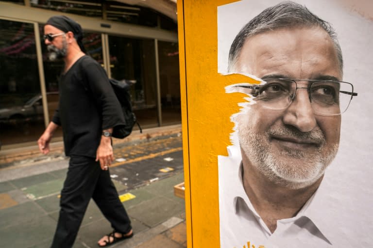 Un hombre pasa junto a un cartel electoral de Alireza Zakani, alcalde de Teherán y candidato a la presidencia, el 23 de junio de 2024 en la capital iraní (Raheb Homavandi)