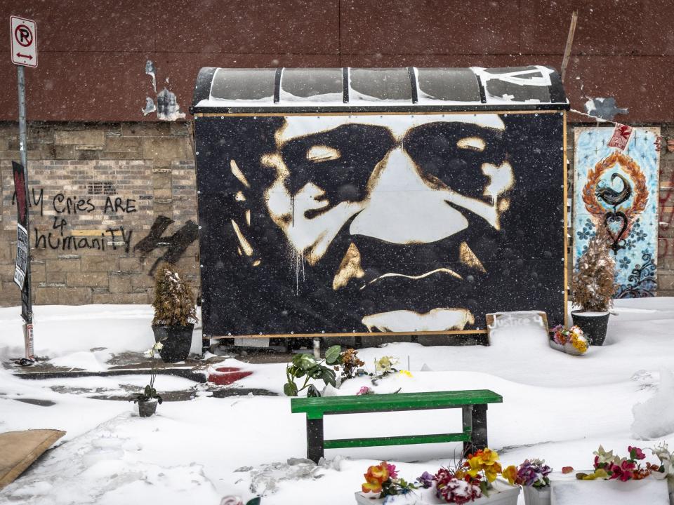 A memorial with George Floyd's face on a snow-covered street.