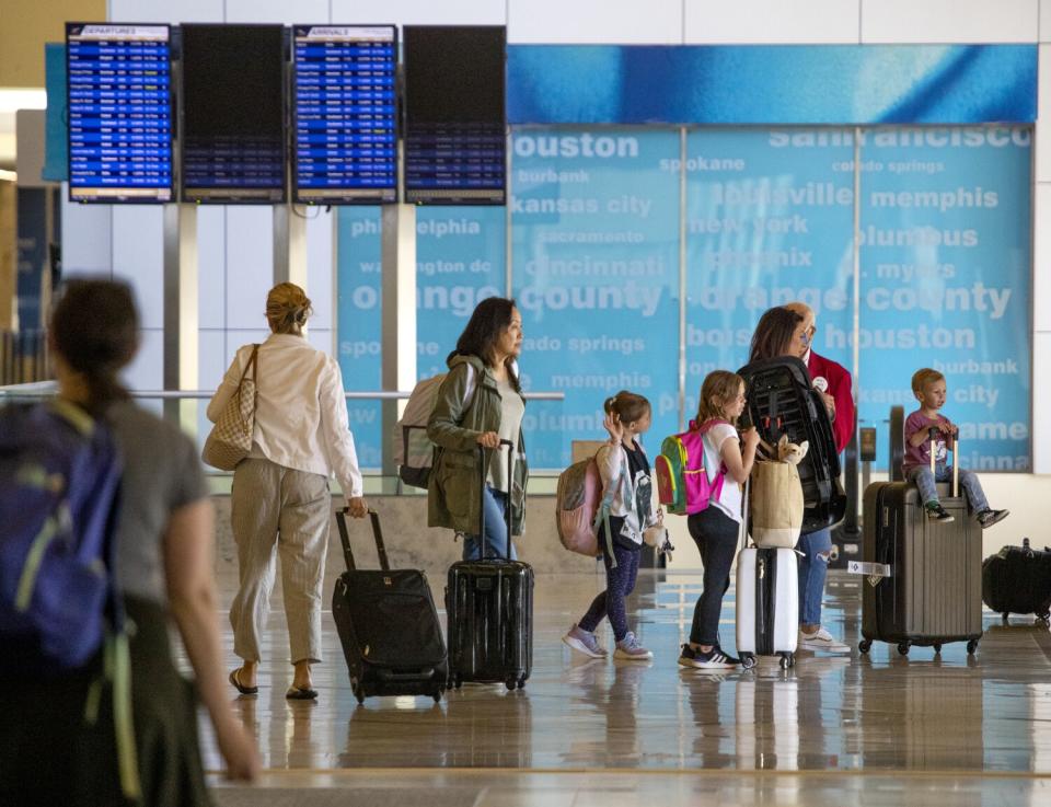 Memorial Day weekend travelers wait in line at John Wayne Airport in Orange County.