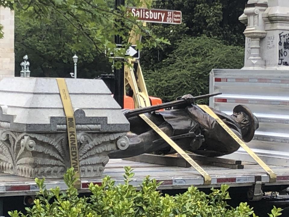 The statue of a Confederate soldier and plinth sit on a flatbed truck at the Old Capitol in Raleigh, N.C., on Sunday, June 21, 2020. After protesters pulled down two smaller statues on the same monument Friday, North Carolina Gov. Roy Cooper ordered the removal of several other monuments to the Confederacy, citing public safety concerns. (AP Photo/Allen G. Breed)