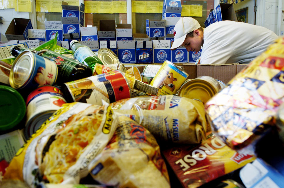 Ryan Hauck a worker at the North York Food Bank sorts through a box of items. (Photo by Carlos Osorio/Toronto Star via Getty Images)