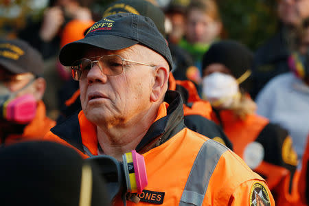 A member of a search and rescue crew listens to a briefing before searching for human remains in the aftermath of the Camp Fire in Paradise, California, U.S., November 16, 2018. REUTERS/Terray Sylvester