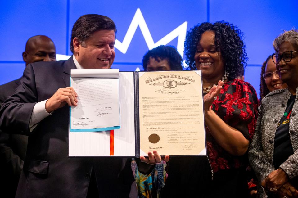 Illinois Gov. JB Pritzker and Illinois State Sen. Kimberly Lightford, D-Maywood, hold up the bill marking Juneteenth an official state holiday in Illinois during a bill signing at the Abraham Lincoln Presidential Library in Springfield, Ill., Wednesday, June 16, 2021. [Justin L. Fowler/The State Journal-Register] 