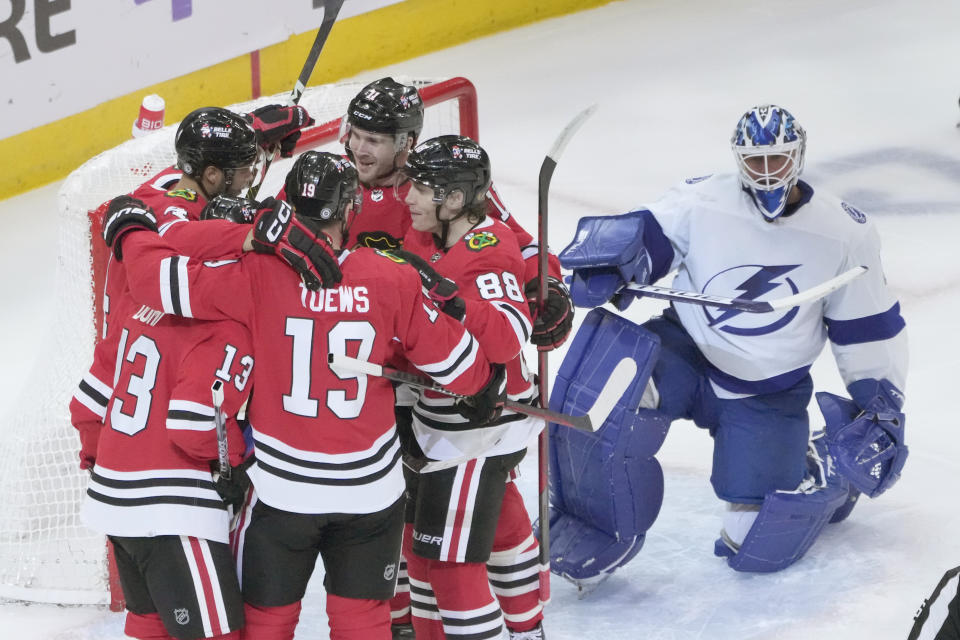 Chicago Blackhawks' Seth Jones, top left, clelbfates his goal with teammates as Tampa Bay Lightning goaltender Brian Elliott watches during the first period of an NHL hockey game Tuesday, Jan. 3, 2023, in Chicago. (AP Photo/Charles Rex Arbogast)