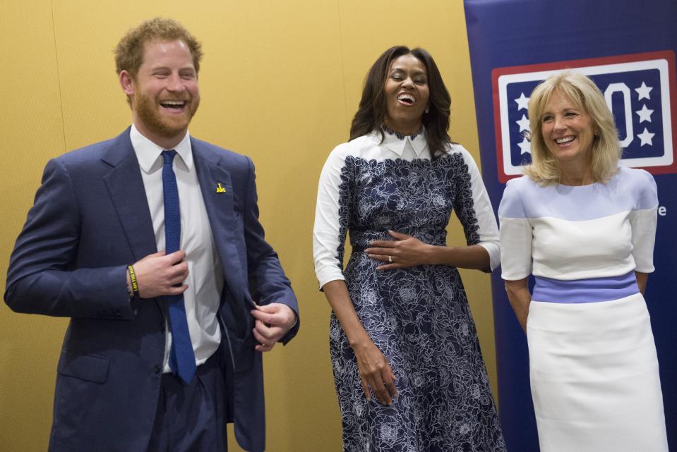 Harry, first lady Michelle Obama and Jill Biden laugh as they listen to a music presentation by wounded warriors at the USO Warrior and Family Center at Fort Belvoir, Virginia, on Oct. 28, 2015. (SAUL LOEB via Getty Images)