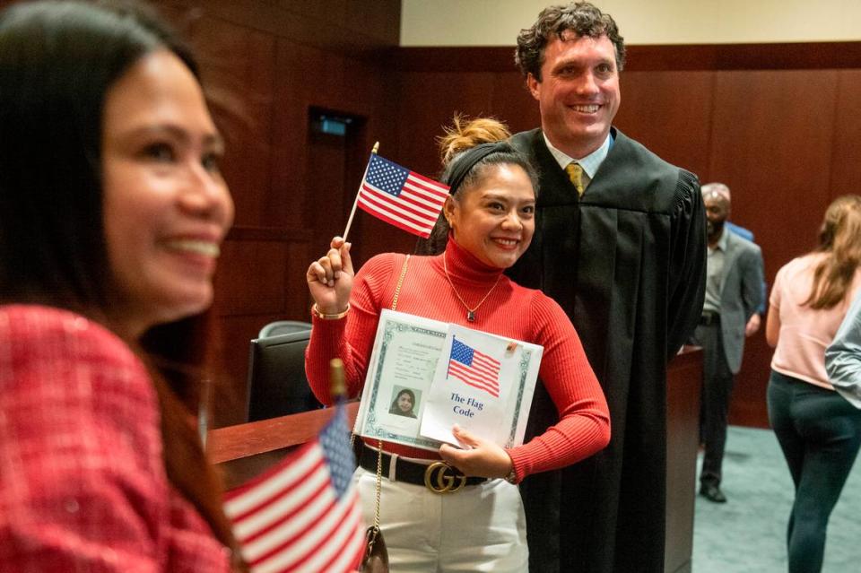 Newly naturalized American citizens take photos with U.S. District Judge Taylor McNeel following a naturalization ceremony at Dan M. Russell Courthouse in Gulfport on Thursday, Oct. 19, 2023.