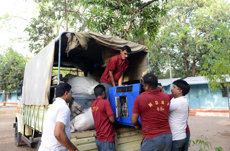 Personnel from India's National Disaster Response Force (NDRF) load a generator to be airlifted to Nepal