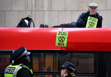 A man sits on top of a train as demonstrators block traffic at Canary Wharf Station during the Extinction Rebellion protest in London, Britain April 25, 2019. REUTERS/Dylan Martinez