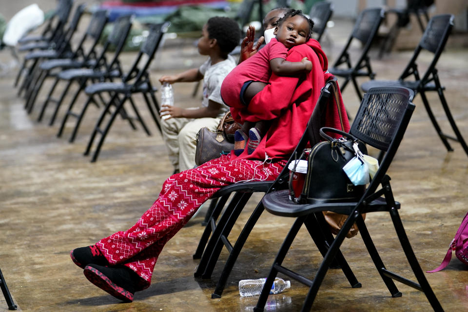 Roslyn Kennedy holds Malaka Kennedy, 1, in a shelter ahead of Hurricane Delta, Friday, Oct. 9, 2020, in Lake Charles, La. Forecasters said Delta — the 25th named storm of an unprecedented Atlantic hurricane season — would likely crash ashore Friday evening somewhere on southwest Louisiana's coast. (AP Photo/Gerald Herbert)