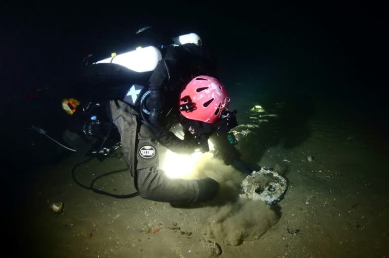 A handout image from Atlantic Wreck Salvage shows diver Joe Mazraani fanning away sand to reveal a 'deadeye' used as part of the sail rigging of Le Lyonnais (Andrew Donn)