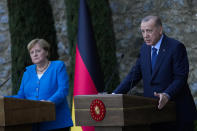 Turkey's President Recep Tayyip Erdogan, right, talks to journalists next to German Chancellor Angela Merkel during a joint news conference following their meeting at Huber vila, Erdogan's presidential resident, in Istanbul, Turkey, Saturday, Oct. 16, 2021. The leaders discussed Ankara's relationship with Germany and the European Union as well as regional issues including Syria and Afghanistan. (AP Photo/Francisco Seco)