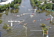 Rescuers use boats to maneuver through an intersection as they work to evacuate people from a flooded area in Weihui in central China's Henan Province, Monday, July 26, 2021. Residents laid flowers on Tuesday at the entrance of a subway station where more than a dozen people died after a record-breaking downpour flooded large swaths of Henan province in central China. (Chinatopix via AP)