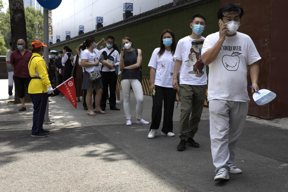 Residents wearing masks to curb the spread of the coronavirus line up for COVID-19 test outside the Worker's Stadium in Beijing on Tuesday, June 30, 2020. Test sites have sprung up through the Chinese capital as test have become a daily normal after the latest outbreak of the coronavirus, (AP Photo/Ng Han Guan)