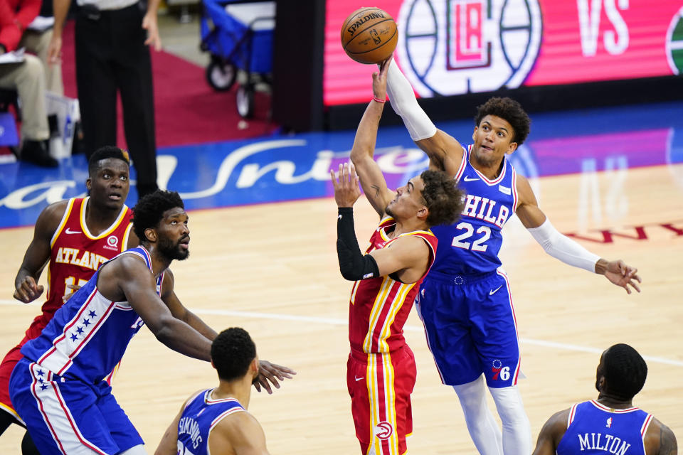 Atlanta Hawks' Trae Young, center, goes up for a shot past Philadelphia 76ers' Matisse Thybulle, right, during the second half of Game 2 in a second-round NBA basketball playoff series, Tuesday, June 8, 2021, in Philadelphia. (AP Photo/Matt Slocum)