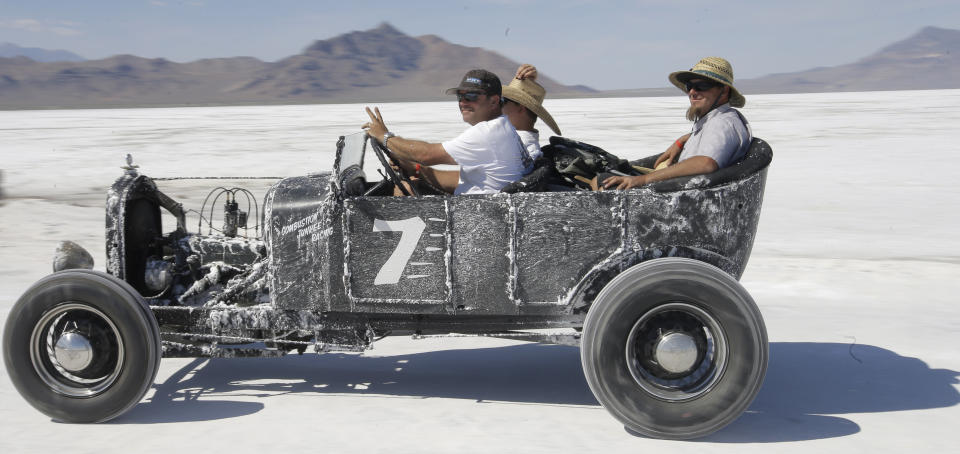 FILE - A car rides along the Bonneville Salt Flats, near Wendover, Utah, on Aug. 13, 2016. The crust keeps tires cool at high speeds and provides an ideal surface for racing — unless seasonal flooding fails to recede or leaves behind an unstable layer of salt. (AP Photo/Rick Bowmer, File)