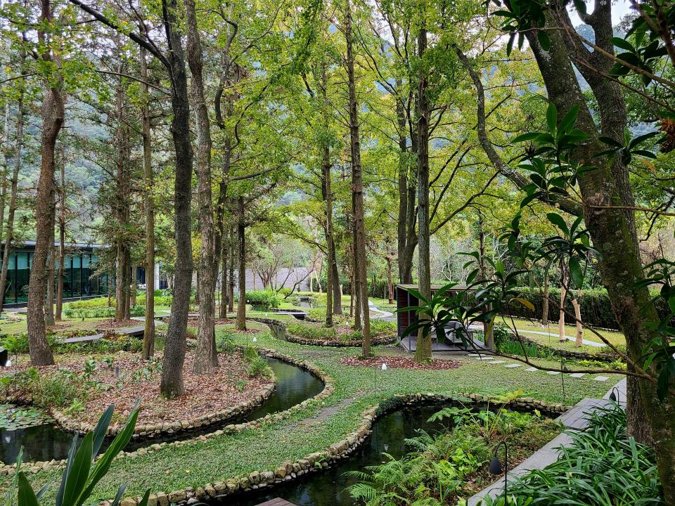 hotel garden with winding paths of water and trees