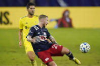 New England Revolution defender Alexander Buttner (28) passes the ball ahead of Nashville SC defender Eric Miller, left, during the first half of an MLS soccer match Friday, Oct. 23, 2020, in Nashville, Tenn. (AP Photo/Mark Humphrey)