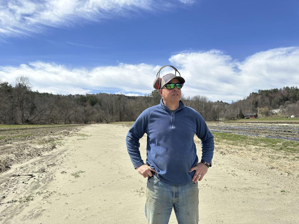 Farmer George Gross, of Dog River Farm in Berlin, Vt., stands in a field covered with silt from December flooding on Wednesday, April 17, 2024. The farm lost nearly all of its produce crops in the catastrophic flooding that hit Vermont last summer. (AP Photo/Lisa Rathke)