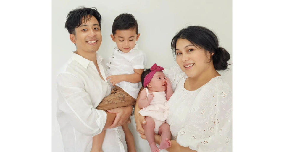 Ian Prahastono holding his son and Katrina Sila holding her daughter.