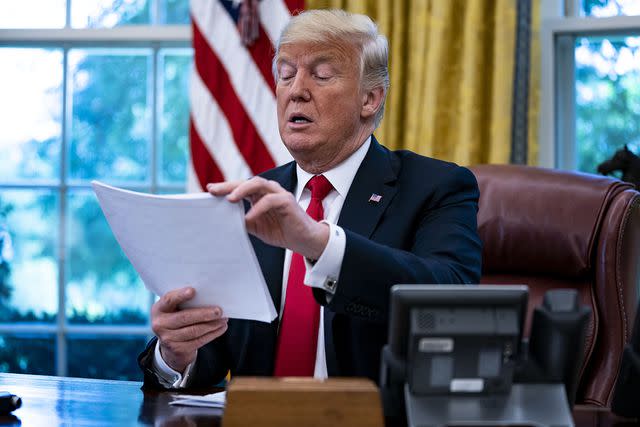 <p>Al Drago/Bloomberg via Getty Images</p> President Donald Trump reviews papers during an interview in the Oval Office on Aug. 30, 2018