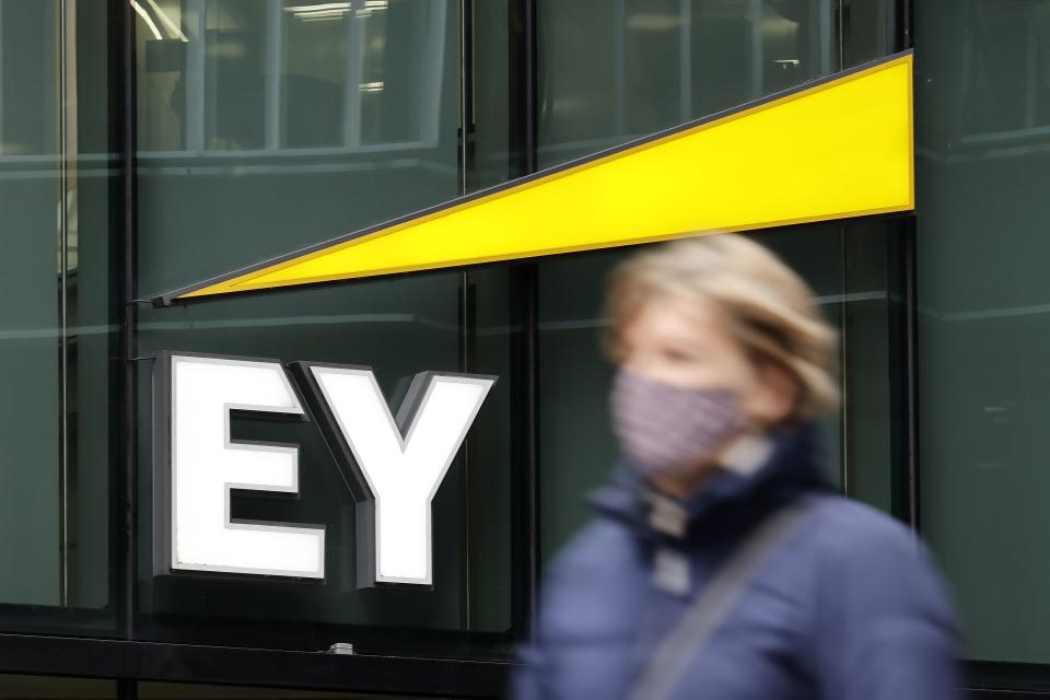 Pedestrians walk past the offices of accounting and auditing firm EY, formerly Ernst & Young, in London on November 20, 2020. - Britain's audit sector, dominated by the so-called Big Four accountancy giants, is shortly expected to discover how it must reinvent itself amid a series of probes into alleged corruption, including one linked to the collapse of German electronic payments group Wirecard. The Department for Business, Energy and Industrial Strategy (BEIS) is reportedly set to publish reform proposals before Christmas amid fraudulent probes into EY-linked activities at Denmark's Danske Bank and Wirecard. EY has been accused of failing to warn about suspicious transactions at Danish bank Danske Bank worth billions of euros. (Photo by TOLGA AKMEN / AFP) (Photo by TOLGA AKMEN/AFP via Getty Images)