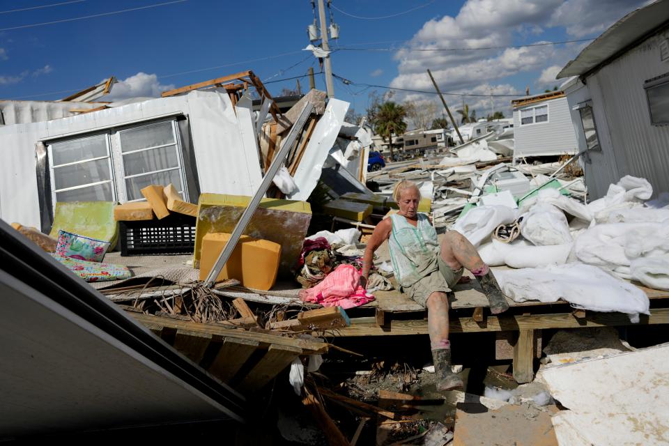 FILE - Kathy Hickey, 70, carefully climbs across a ruined trailer as she picks her way through debris to where she and her husband Bruce had a winter home, a trailer originally purchased by Kathy's mother in 1979, on San Carlos Island in Fort Myers Beach, Fla., Oct. 5, 2022, one week after the passage of Hurricane Ian. Changes in air patterns as the world warms will likely push more and nastier hurricanes up against the United States' east and Gulf coasts, especially in Florida, a new study said. (AP Photo/Rebecca Blackwell, File)